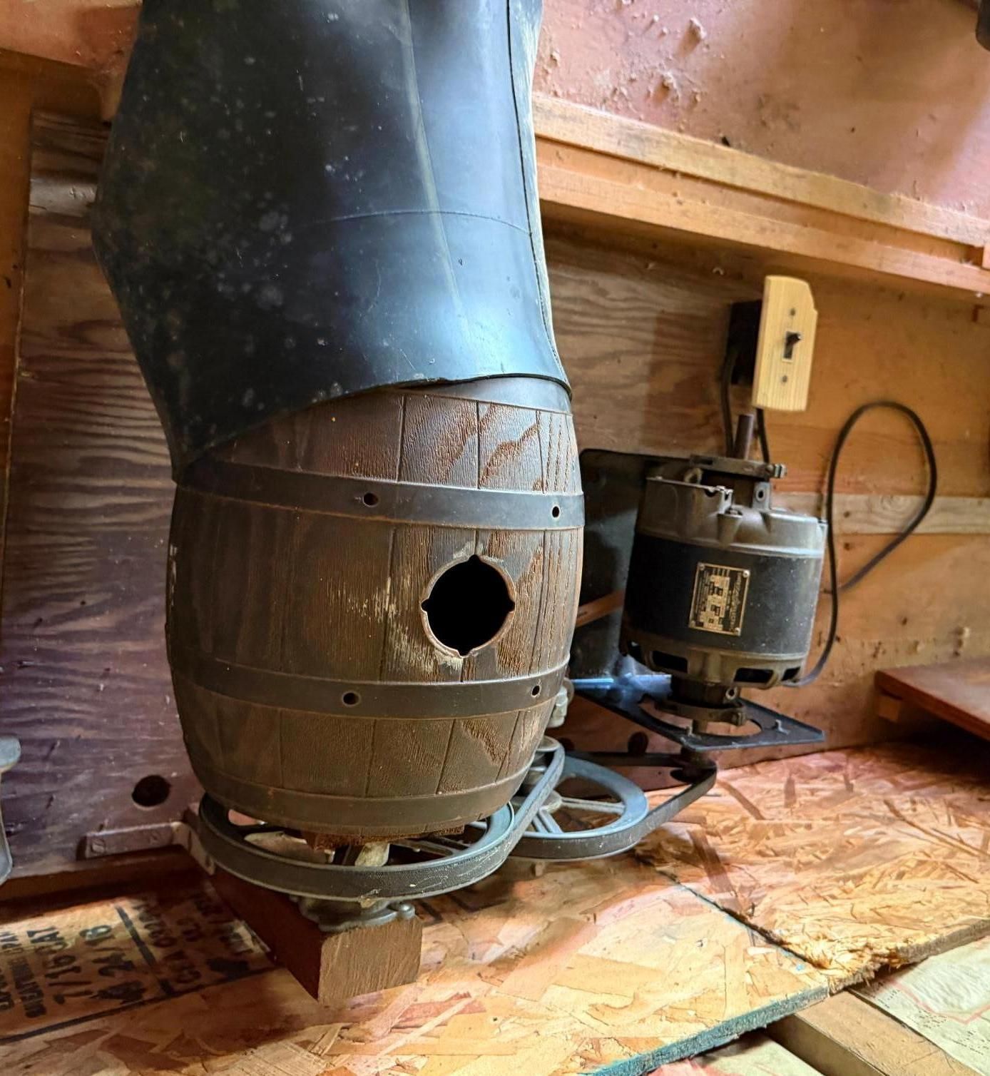 wood stove with a black chimney pipe in a wooden shed or workshop.