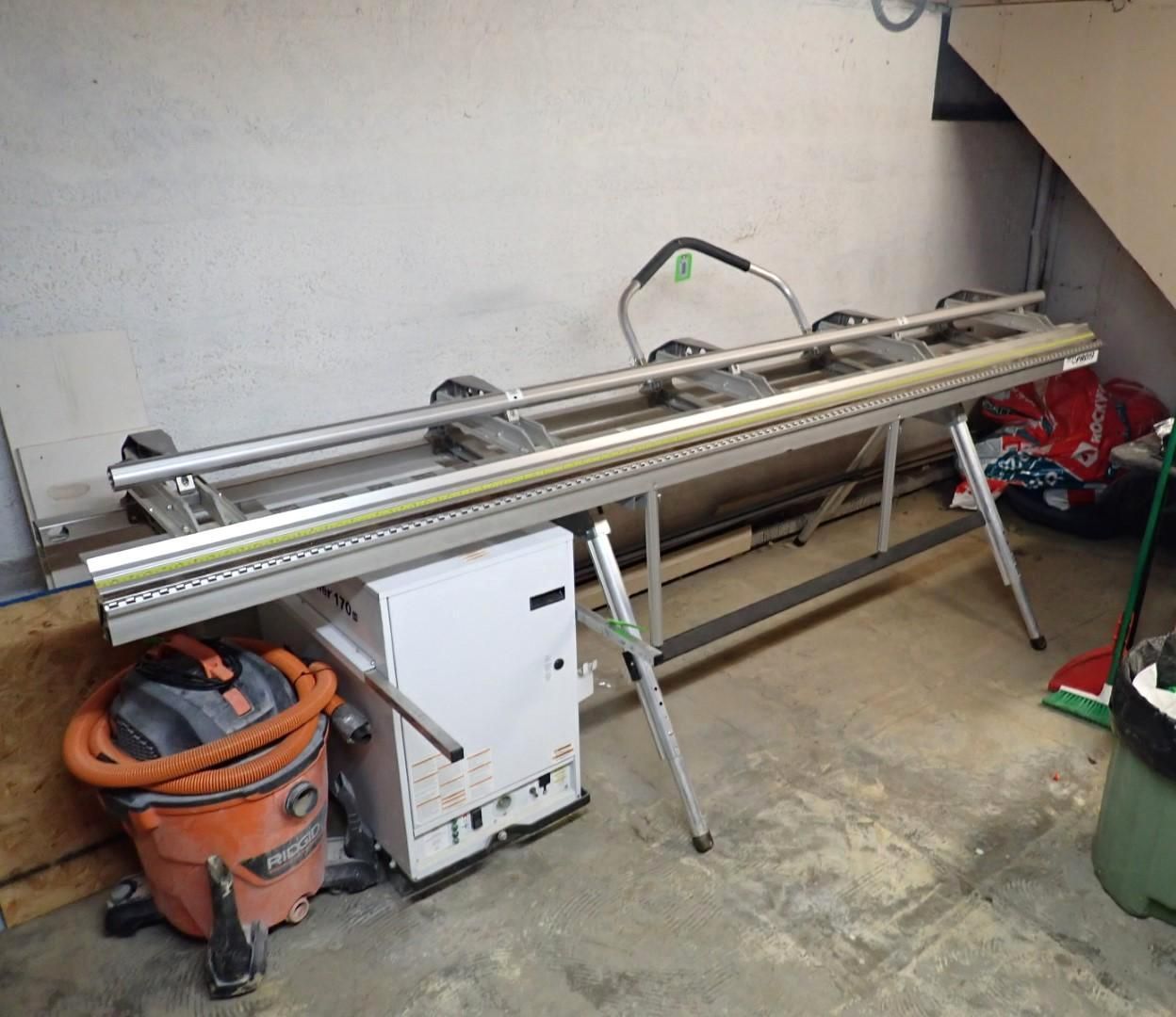 Long metal shear machine on a stand with a vacuum and equipment.