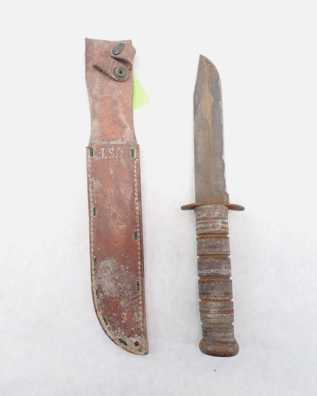 Antique knife and leather sheath. Knife has a stacked handle.