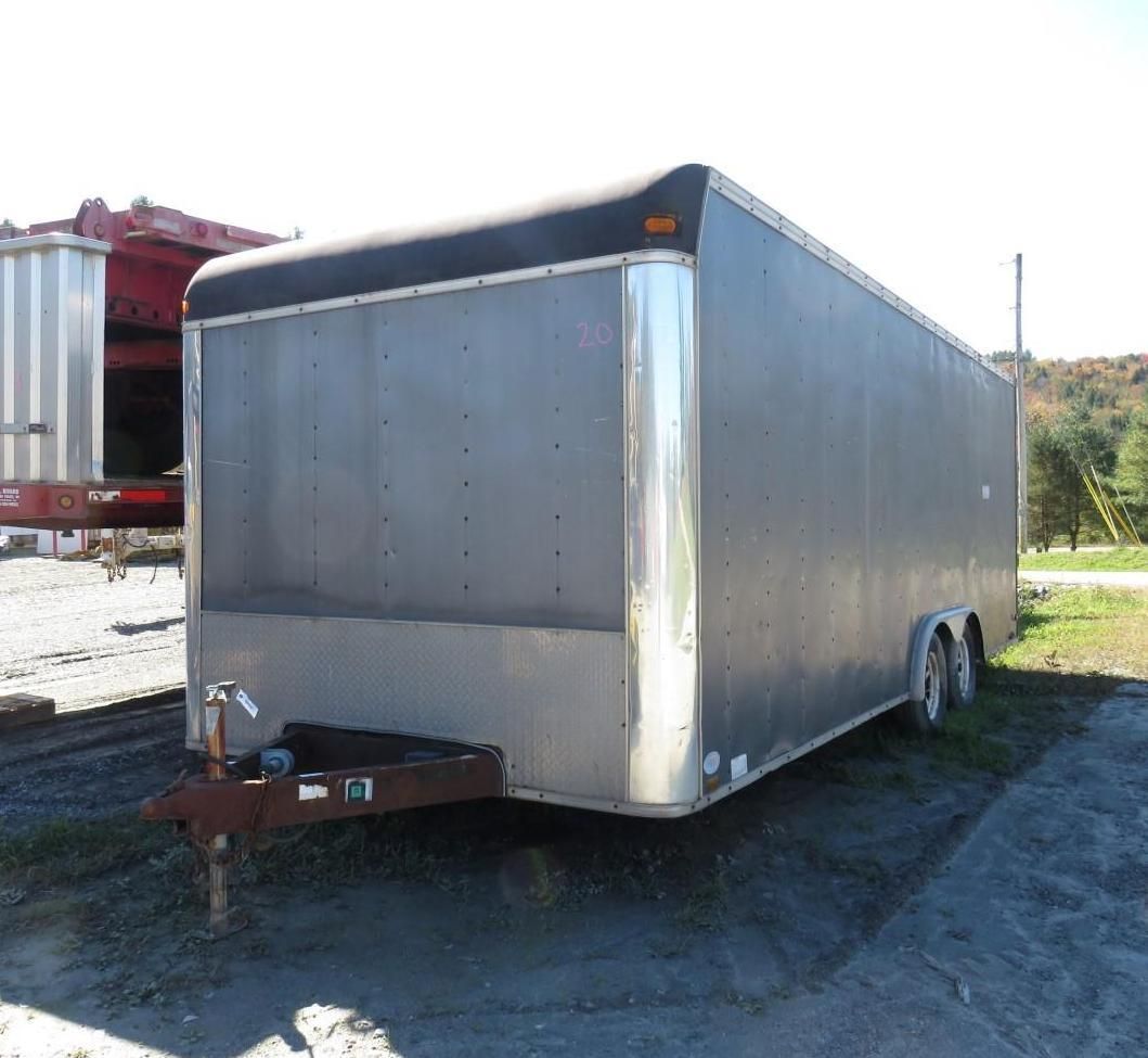 Gray enclosed cargo trailer parked outside on a sunny day.
