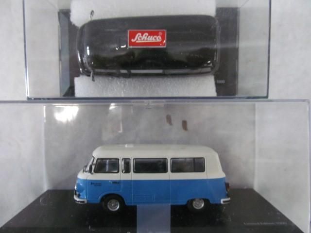 Model bus in blue and white, displayed in a clear case below a second sealed model.