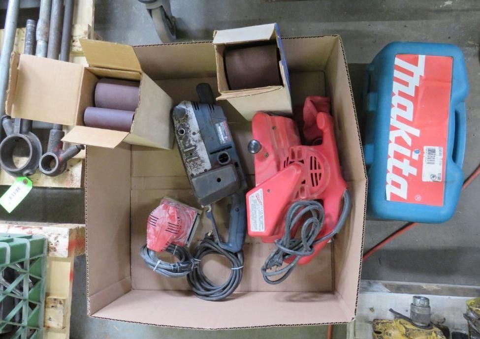 Box of power tools: sanders and accessories, including a Makita case.