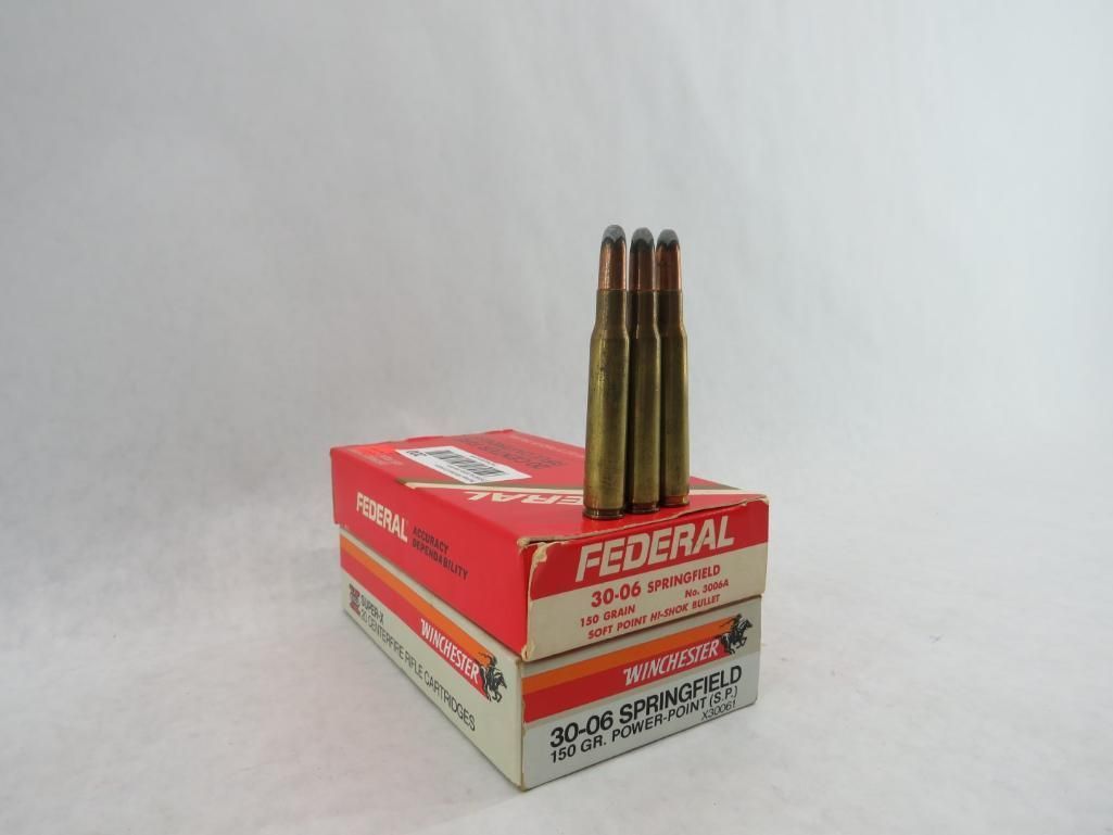 Three rifle cartridges stand on a box of Federal ammunition, red and white.