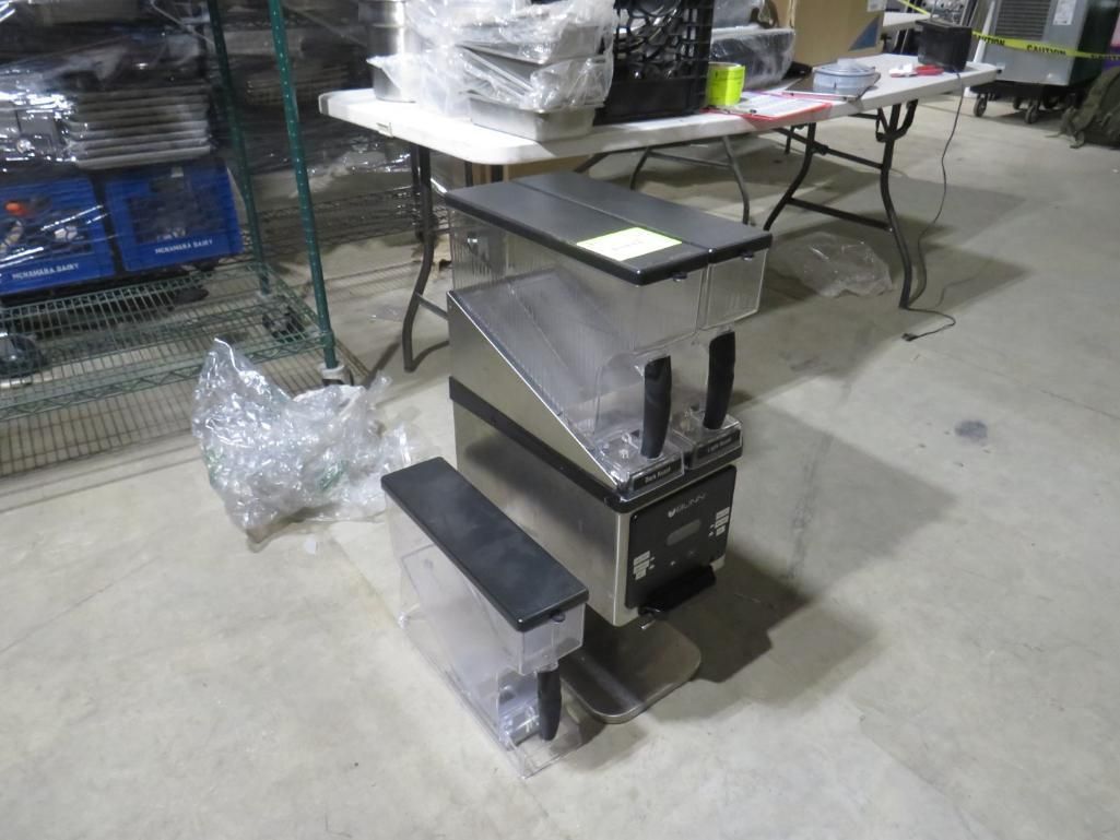 Stainless steel countertop condiment dispensers stacked on the floor.