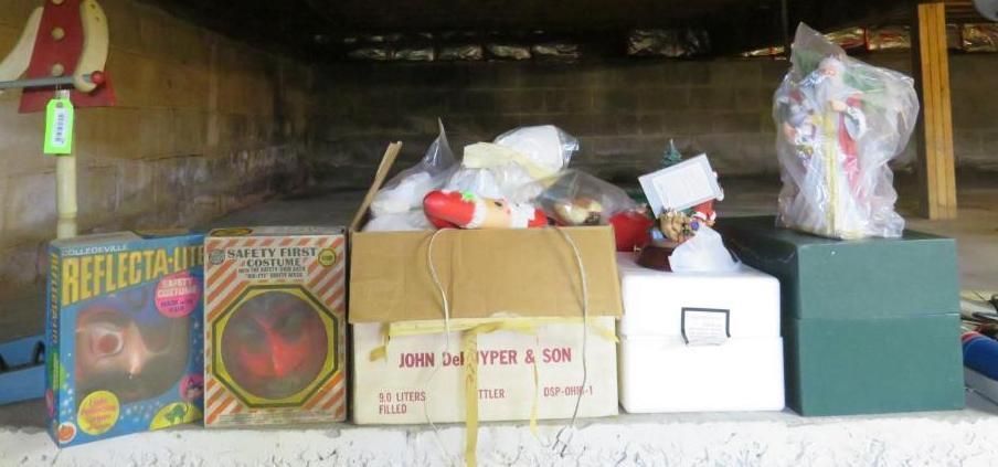 Boxes and items on a shelf under a concrete structure; including toy boxes, other boxes, and a clear bag.