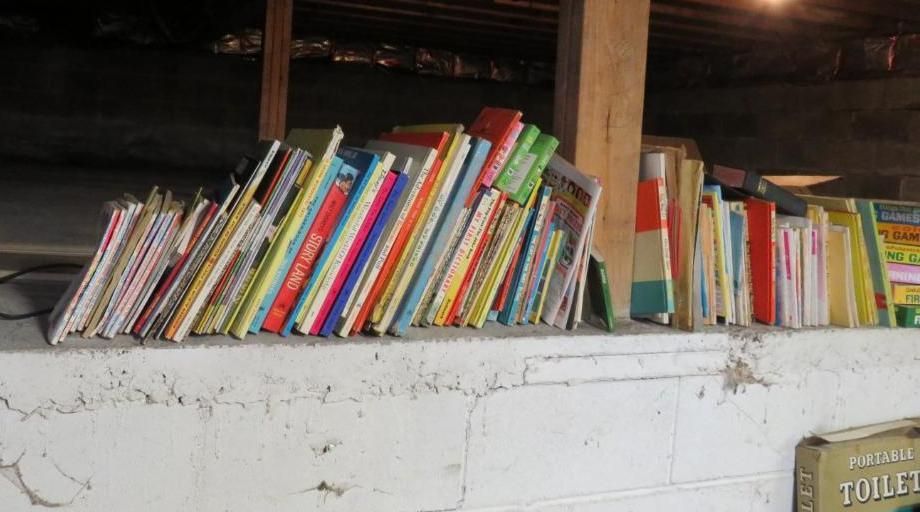 Books stacked on a concrete ledge, indoors.