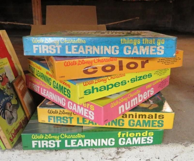 Stack of vintage Walt Disney First Learning Games boxes in various colors.