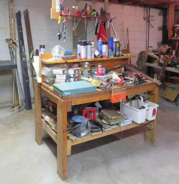 Workbench in a basement, with tools and supplies.