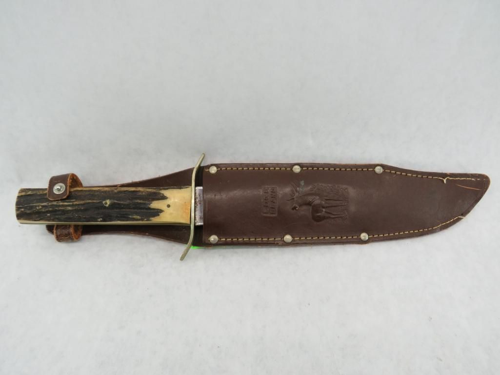 Knife in leather sheath, brown handle and sheath, silver blade.