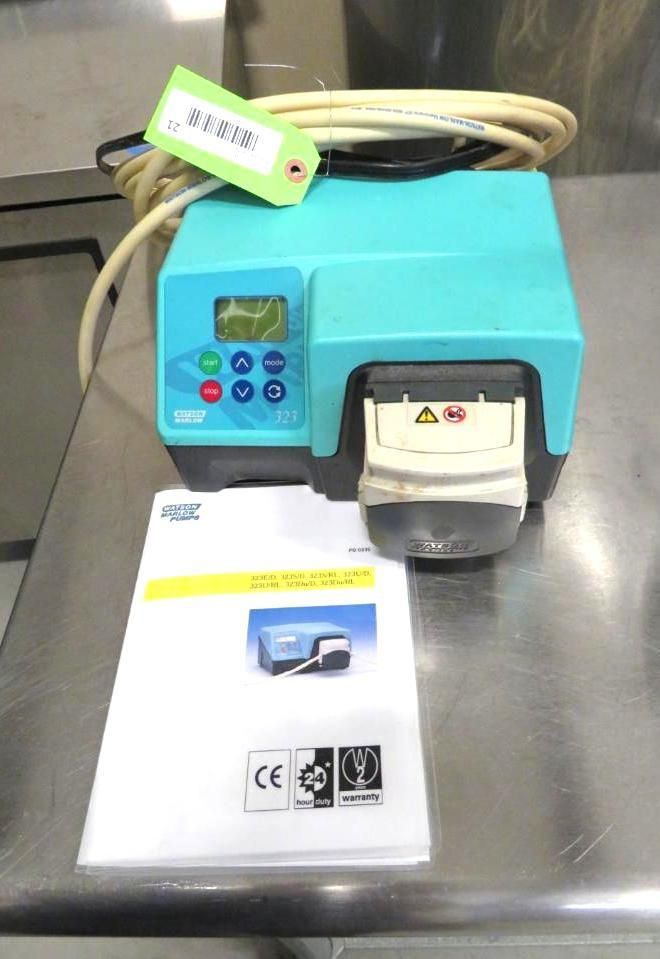 Blue peristaltic pump with control panel and instruction manual on a stainless steel surface.