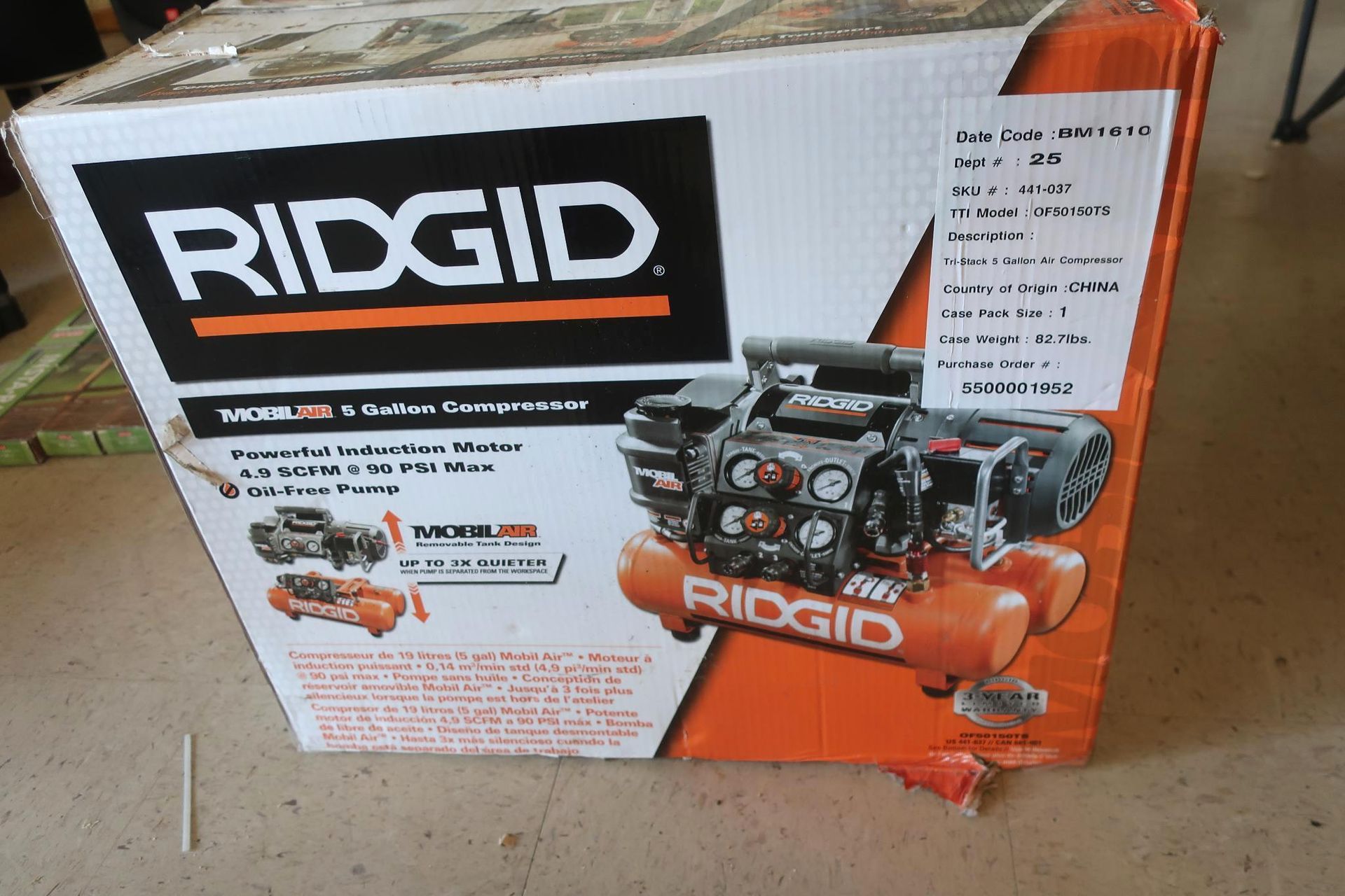 Ridgid air compressor box, orange and black, on a light surface.