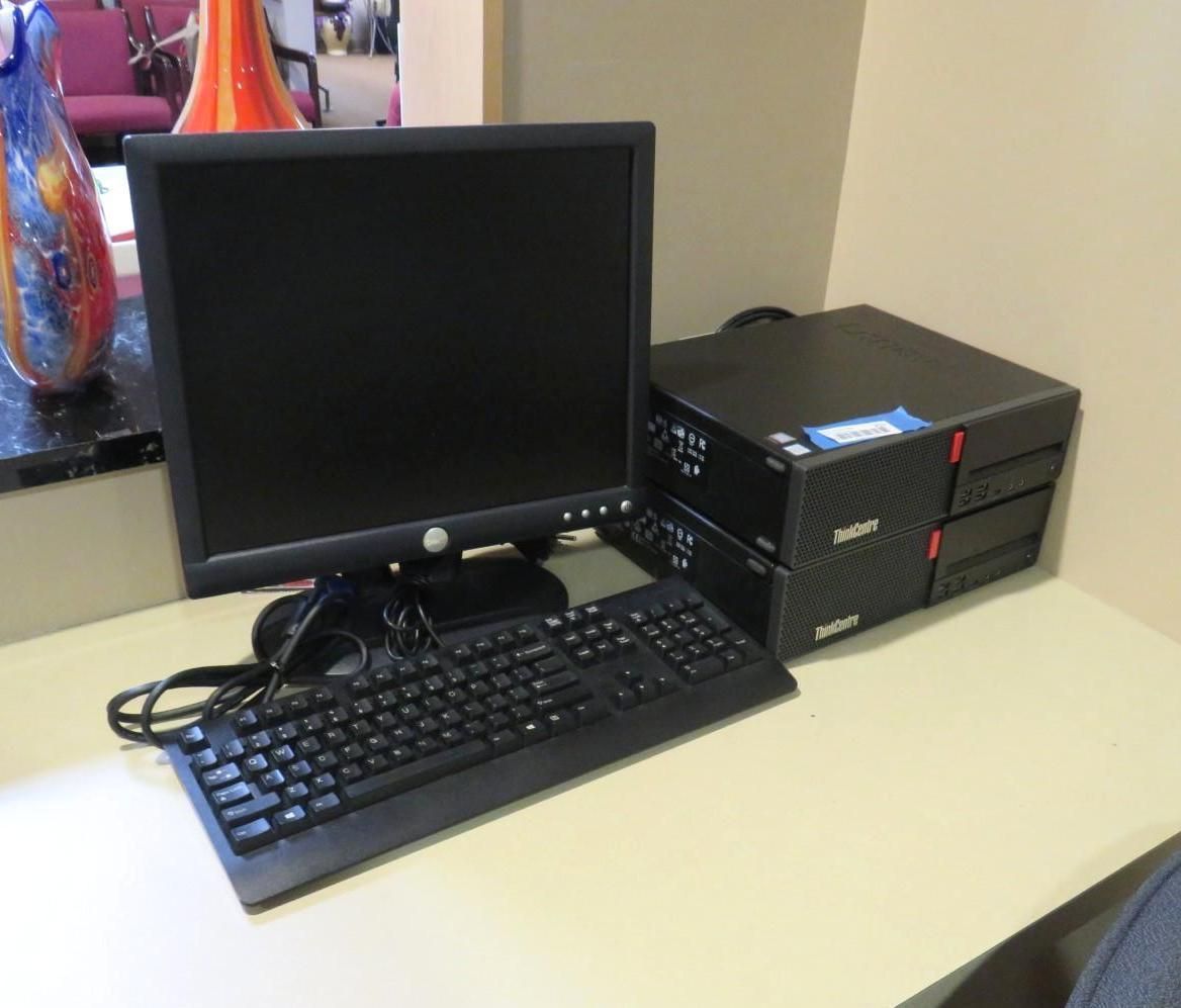 Computer workstation: Dell monitor, keyboard, and two stacked black computer towers on a beige desk.