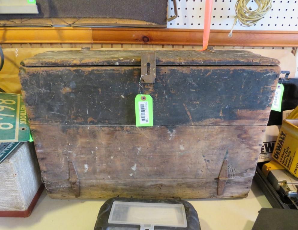 Wooden toolbox with a metal clasp, on a shelf.