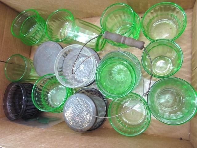 Green glass tumblers and jars in a cardboard box; some with lids and a wire handle.