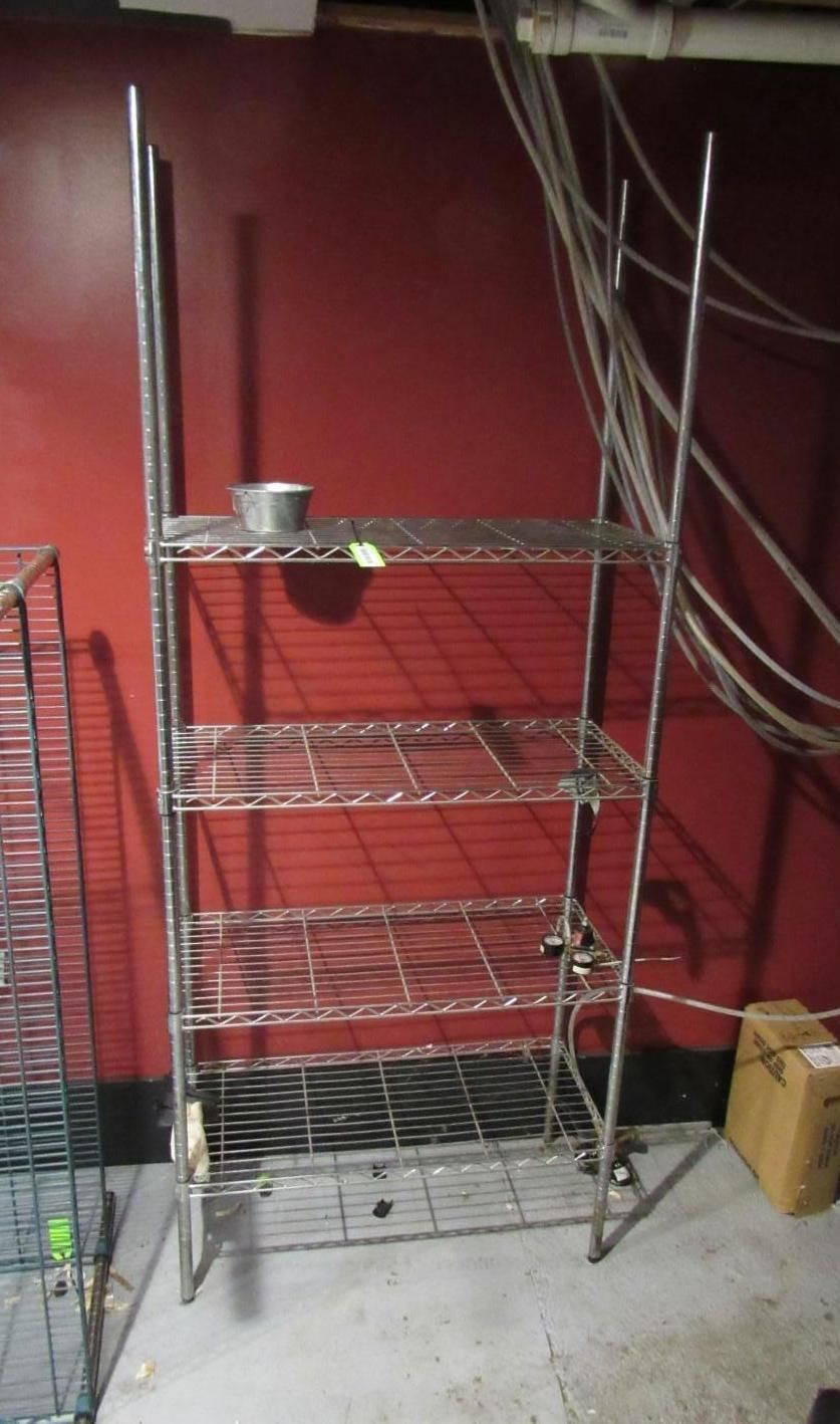 Metal shelving unit against a red wall.