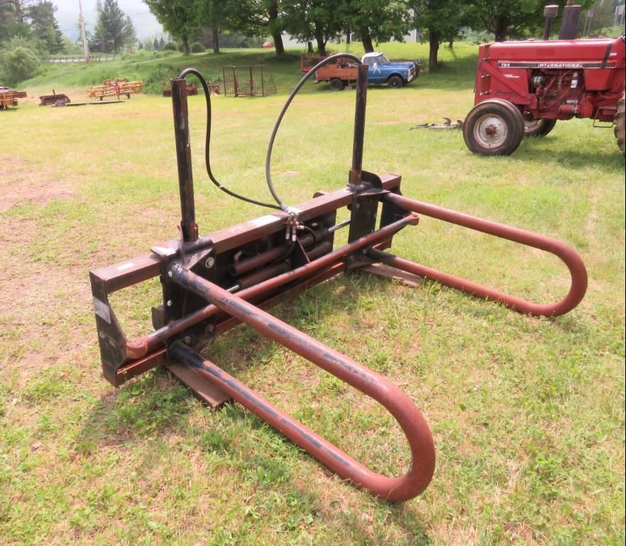 Hay bale grapple in a grassy field.