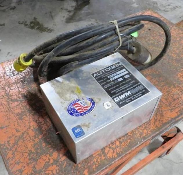 Silver Autogas control box with attached black cord, on an orange surface.