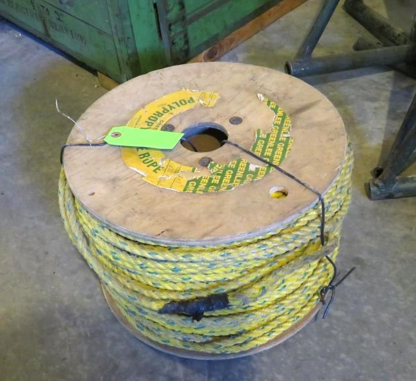 Yellow and green rope wound on a wooden spool, with a green tag.