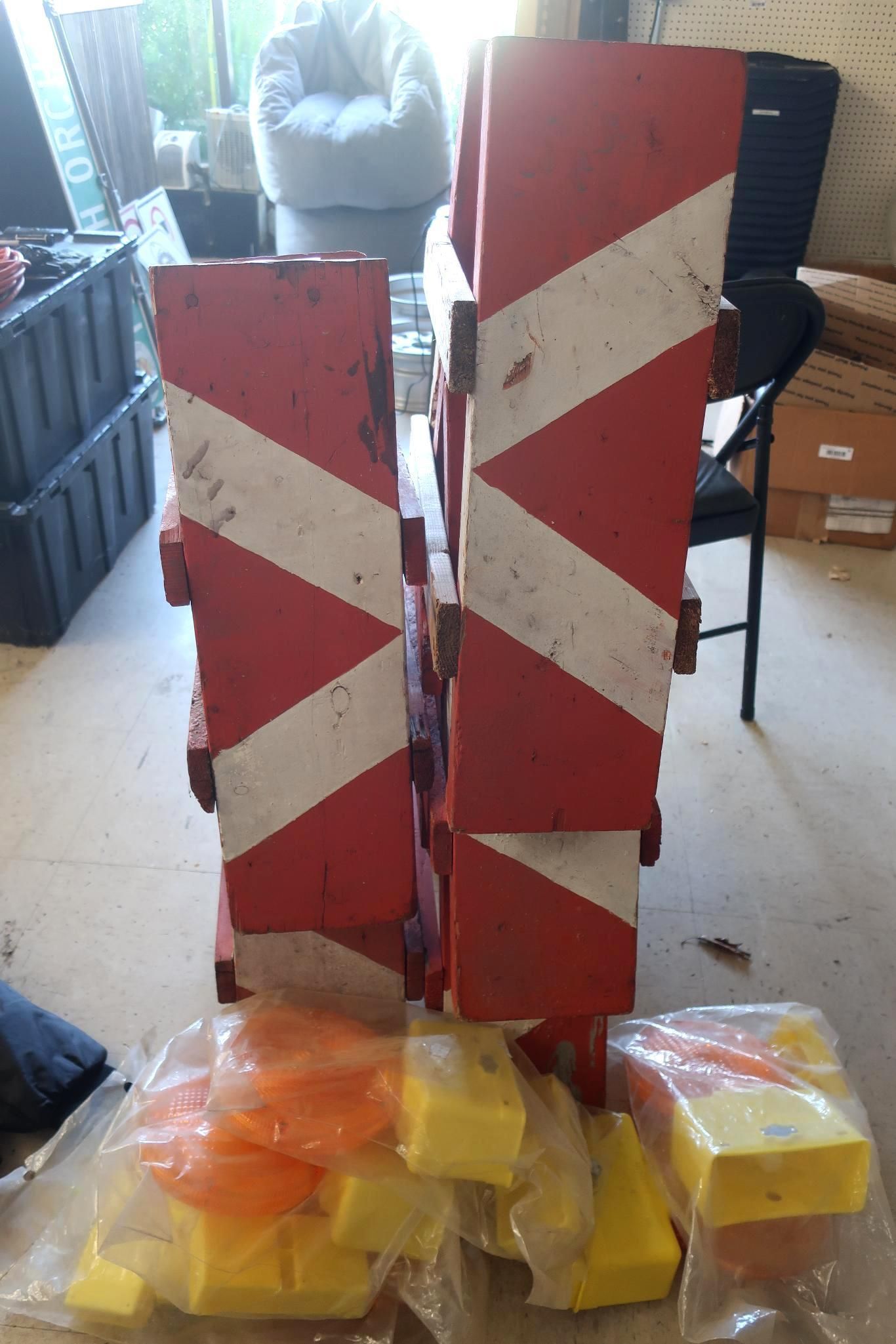 Red and white striped barrier posts stacked with orange and yellow plastic blocks in front.