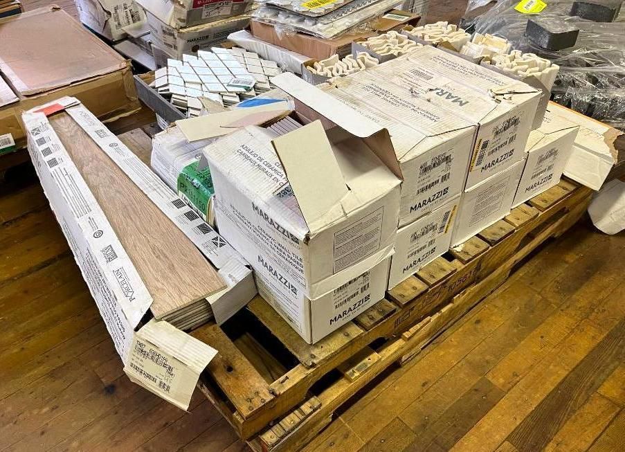 Wooden pallet with boxes of tiles, wood flooring, and mosaic pieces.