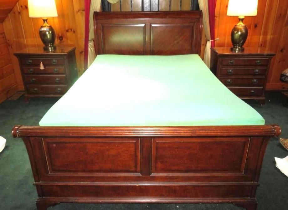 Bedroom with a dark wooden bed, two nightstands, and lamps. Green fitted sheet.