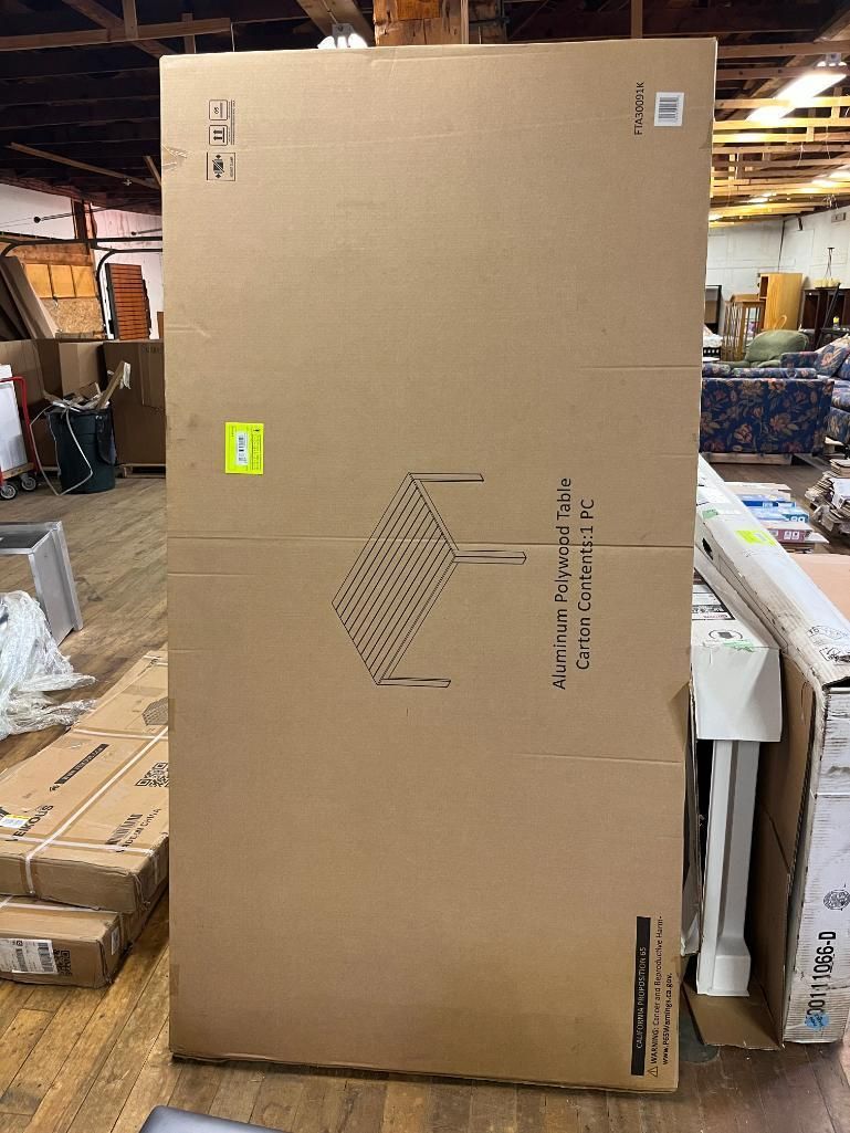 Large cardboard box with informational graphics and labels in a warehouse setting.