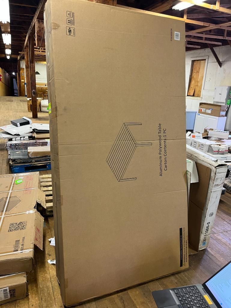Large, upright cardboard box in a warehouse setting, next to other boxes.