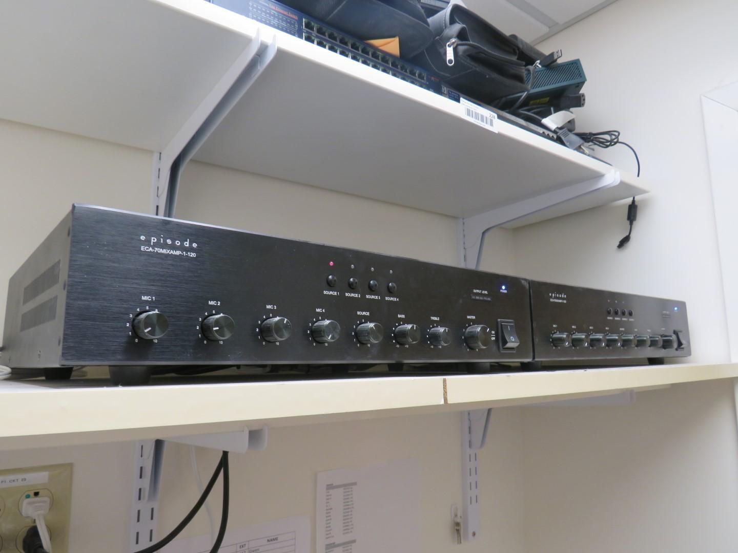 Black audio amplifier with knobs and buttons on a shelf.