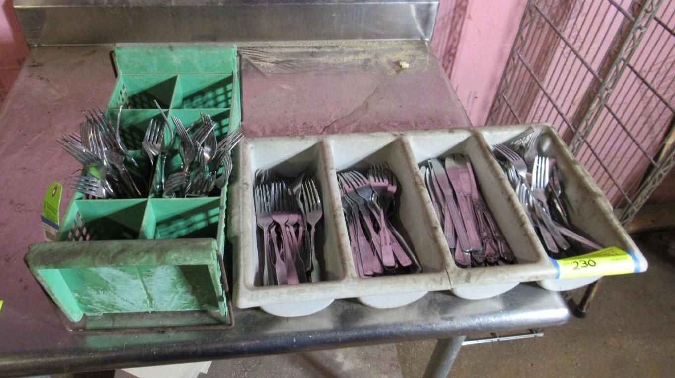 Silverware sorted in a stainless steel station with multiple compartments.
