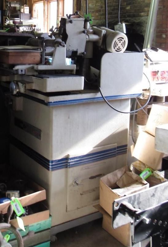 White industrial woodworking machine with blue stripes, in a workshop setting.