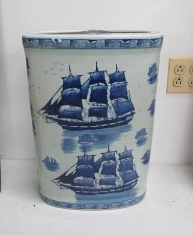 Blue and white porcelain vase decorated with sailing ships on water.