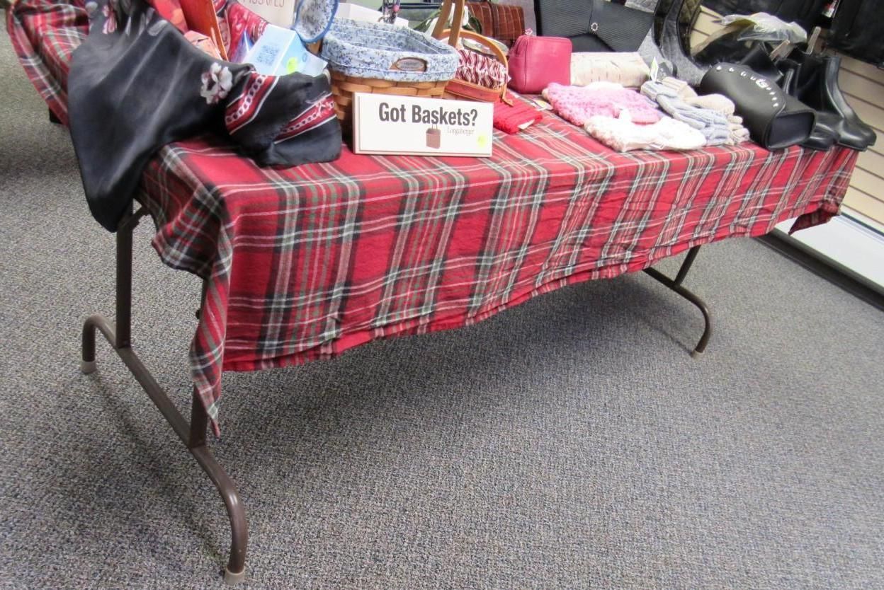 Red plaid-covered table with bags and items.