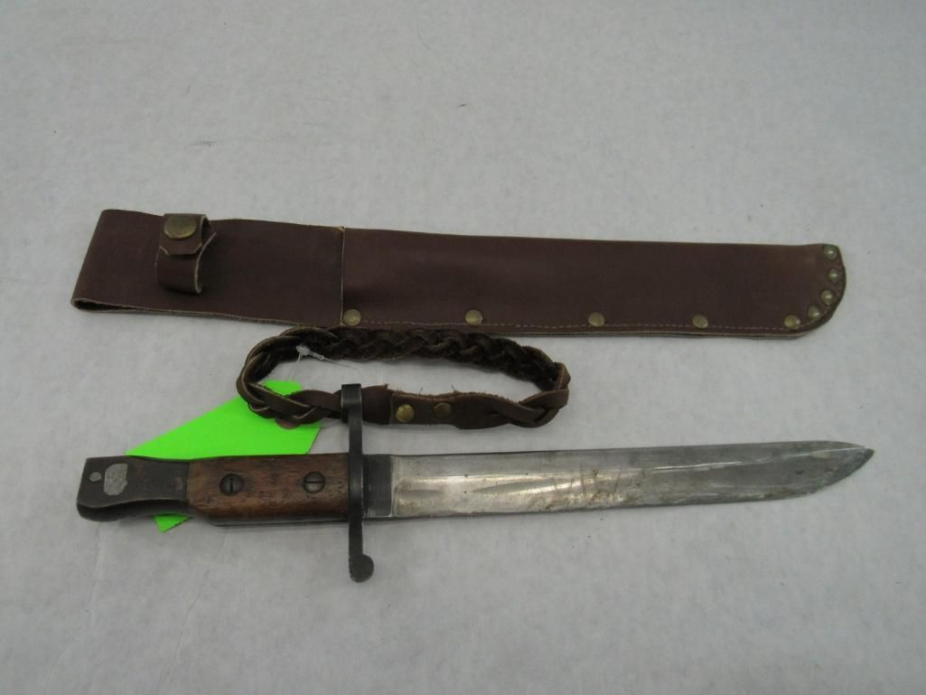 Knife and sheath with braided bracelet on a white surface.