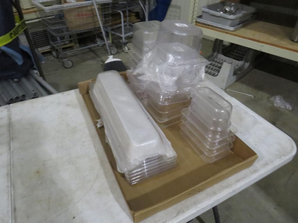 Plastic food containers in a cardboard tray on a white table.
