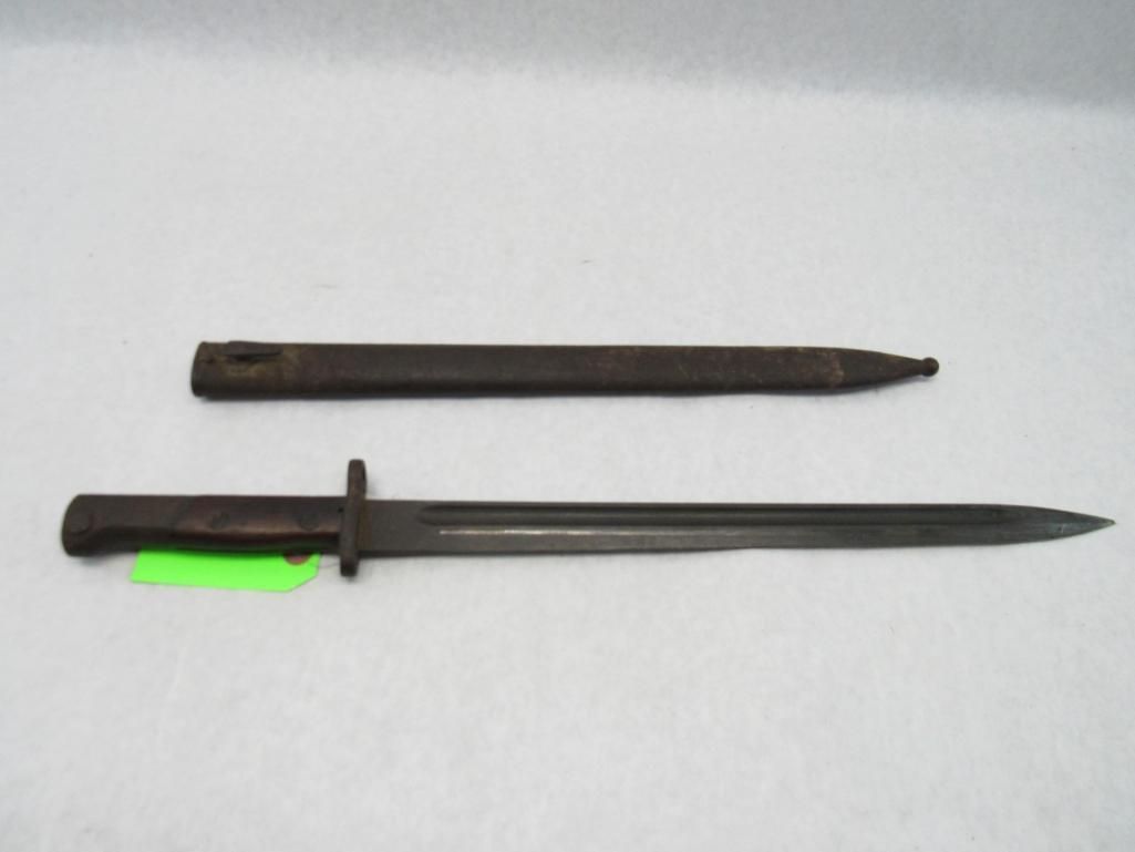 Bayonet and sheath, both dark, with a green tag attached.