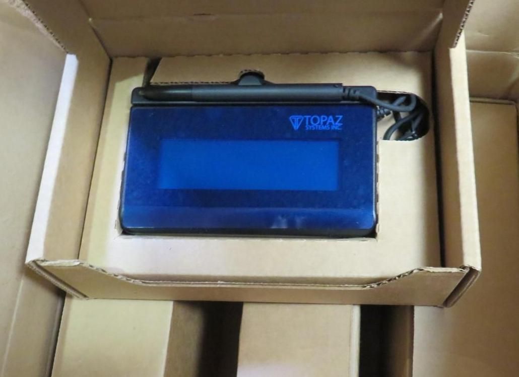 Blue electronic device in a cardboard box, likely for shipping.