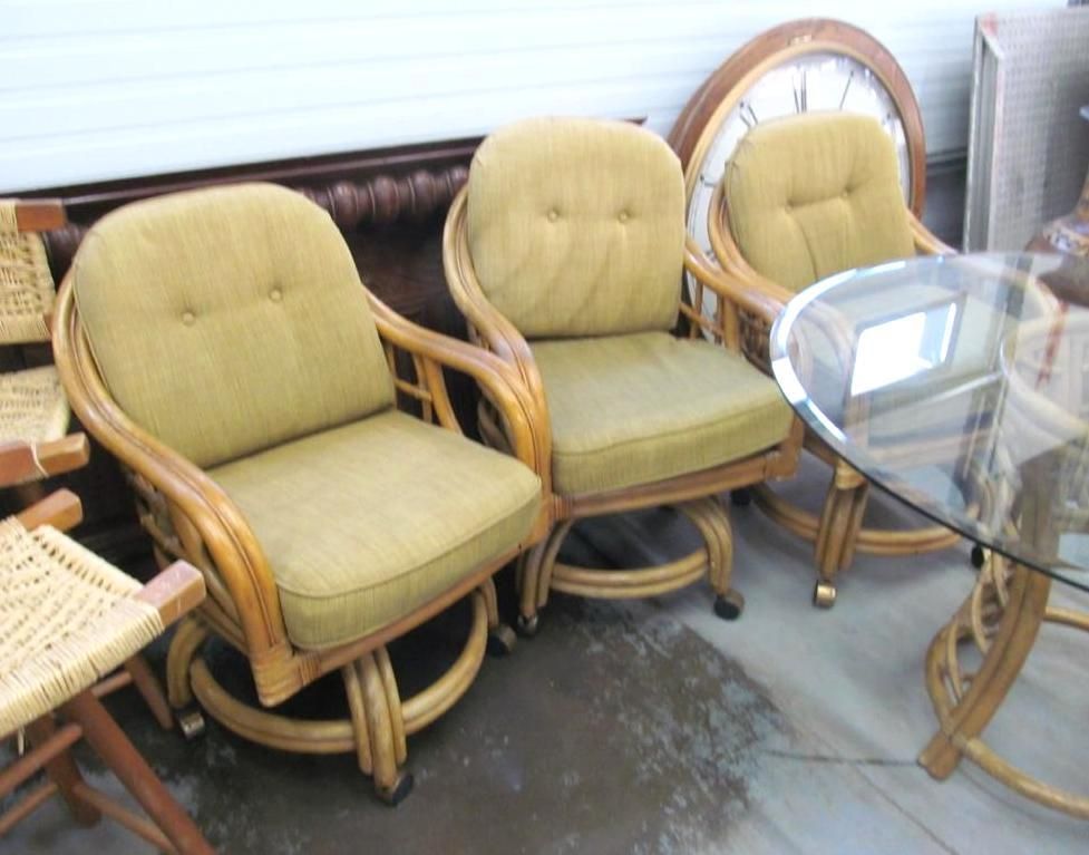 Three swivel chairs with light brown wicker frames and olive cushions.