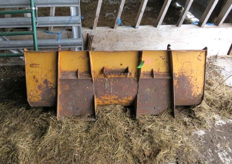 Yellow metal livestock feeder in a barn.