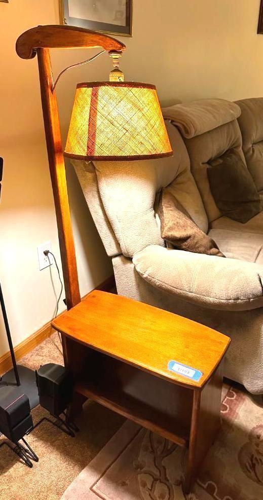 Wooden floor lamp with attached side table, next to a recliner.