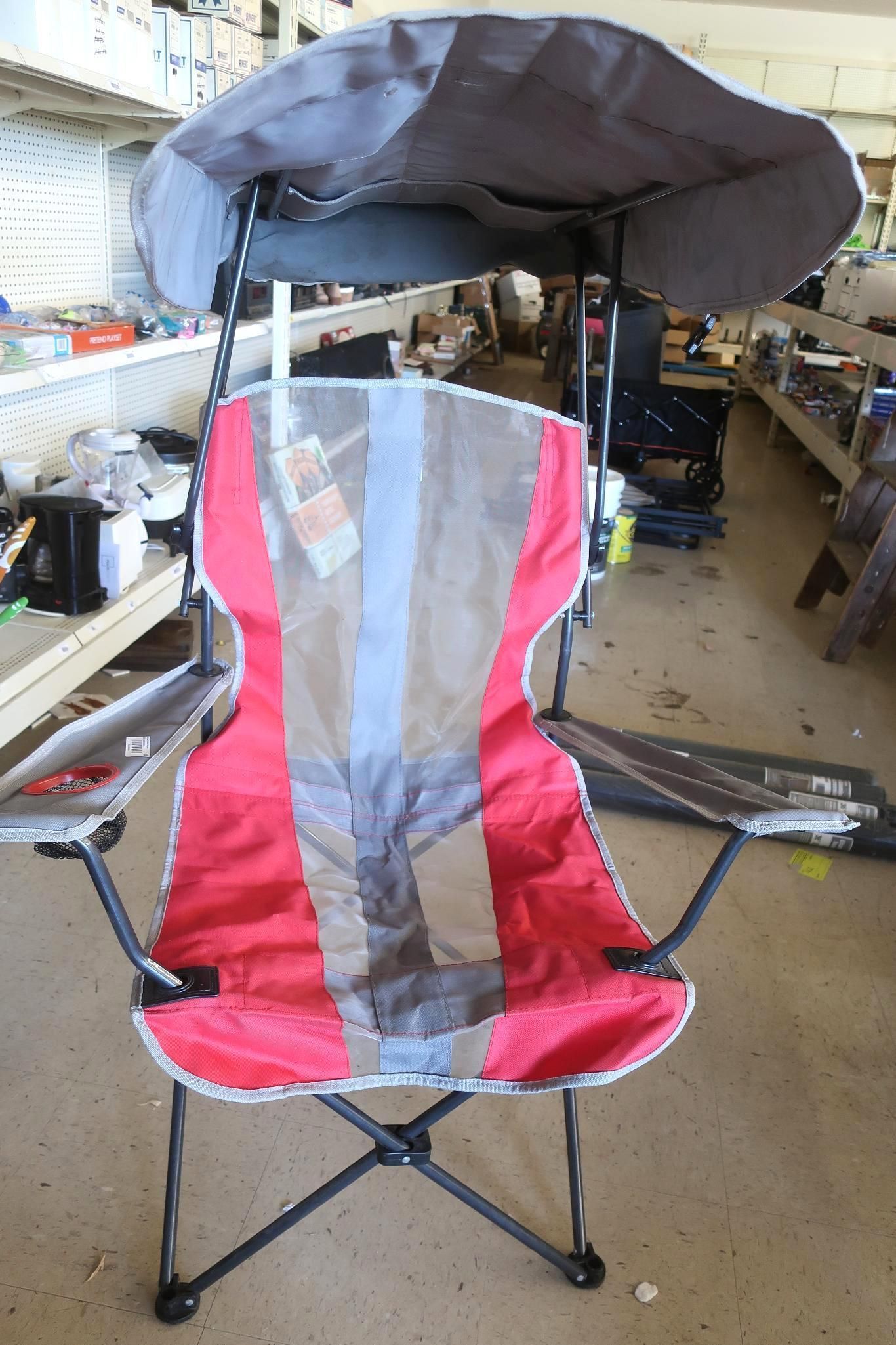Red, gray, and blue camping chair with sun shade.
