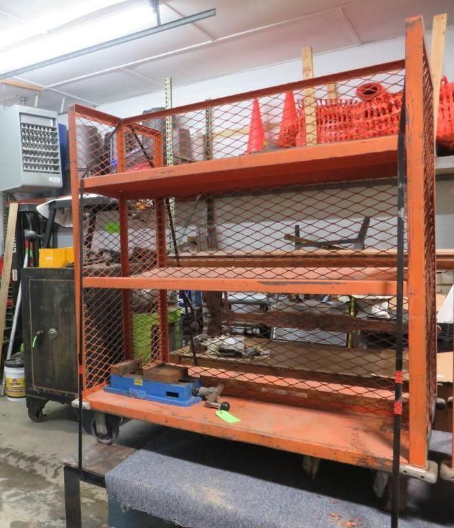 Orange metal shelving cart with mesh sides and multiple shelves, holding tools and cones.