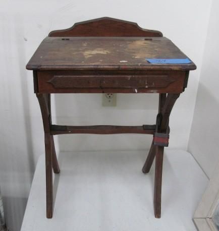 Wooden writing desk with angled legs and a drawer, set on a white surface.