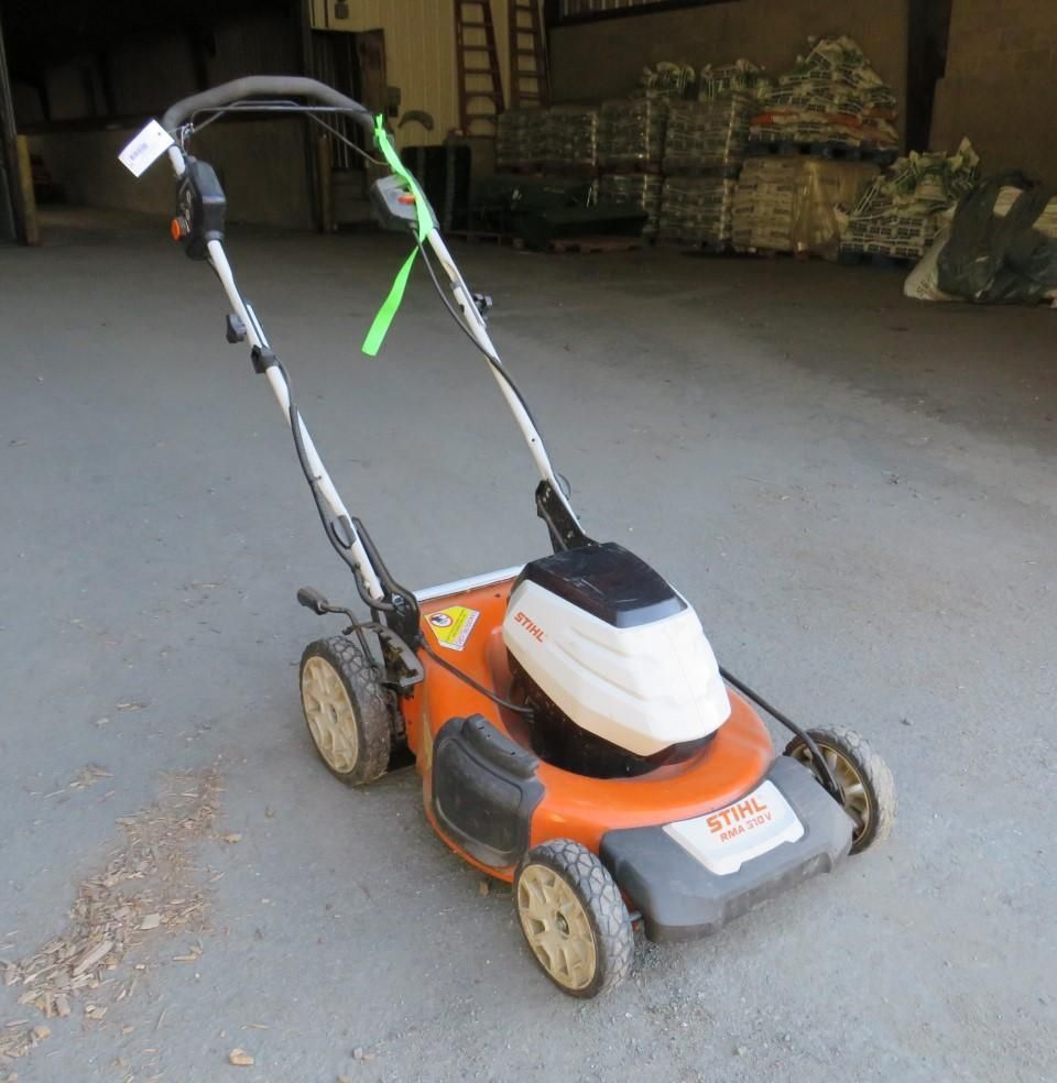 Orange and white Stihl lawn mower on a concrete surface.