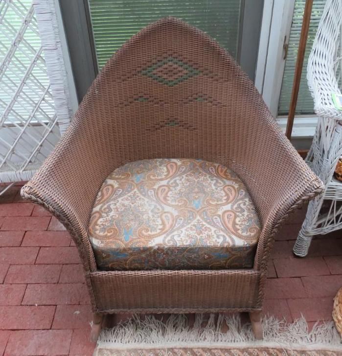 Wicker armchair with patterned cushion, set on a brick patio.