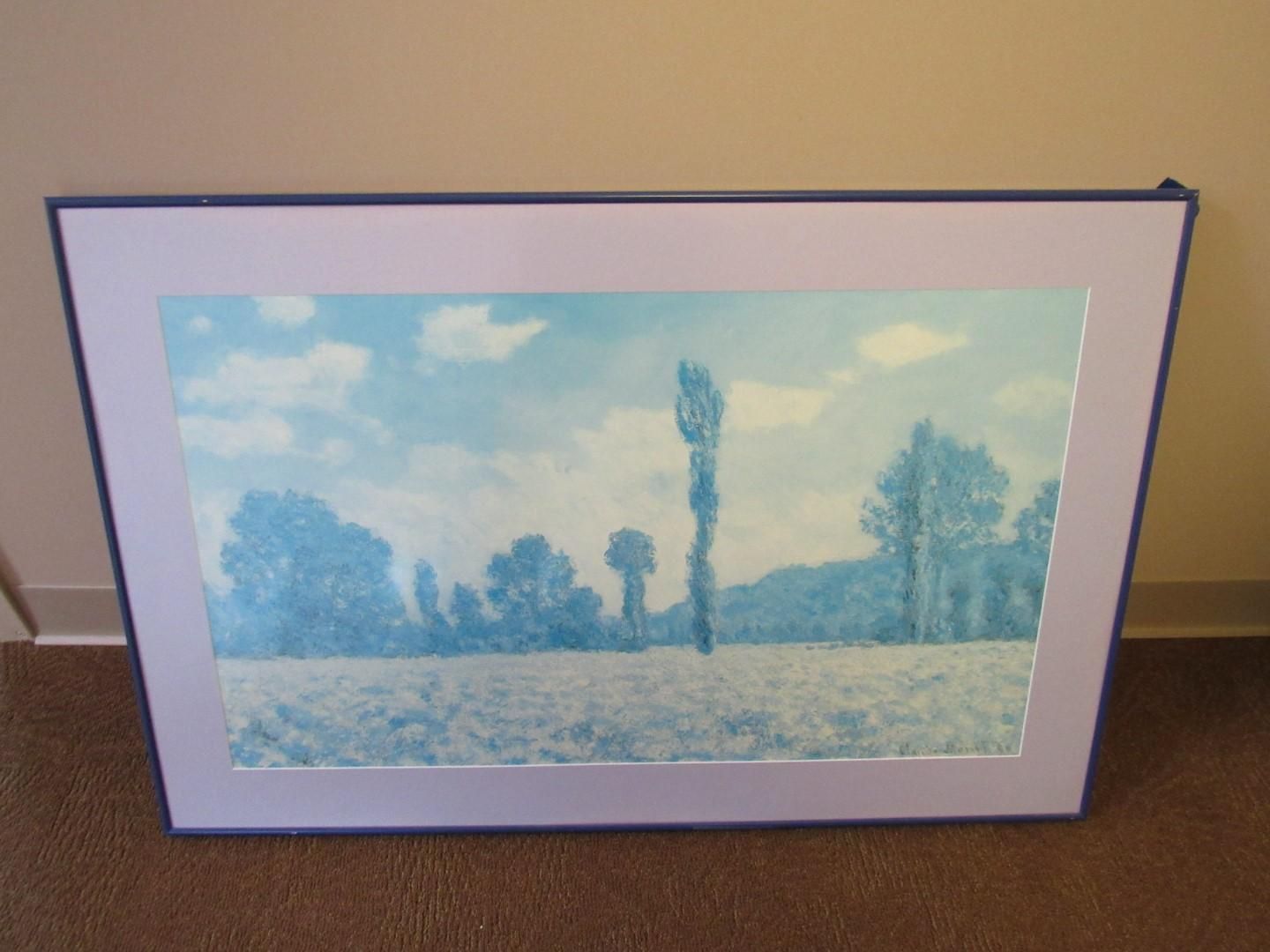 A framed cyanotype landscape print of trees, fields, and cloudy sky.