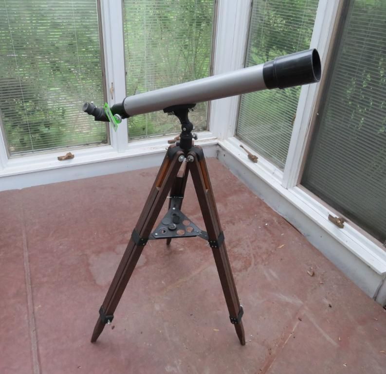 A silver telescope on a wooden tripod.