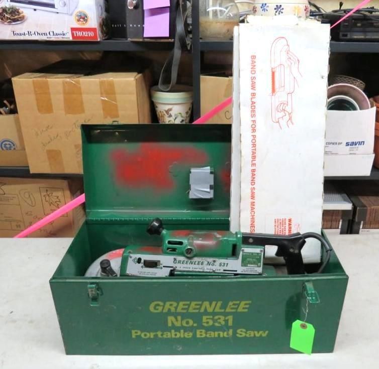 Greenlee No. 531 portable band saw in a green metal case, with a manual, on a shelf with other items.