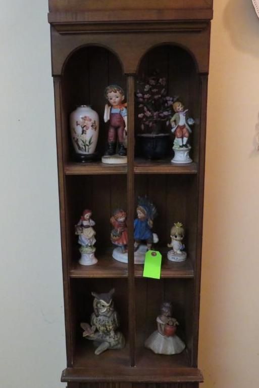 Wooden curio cabinet with figurines.