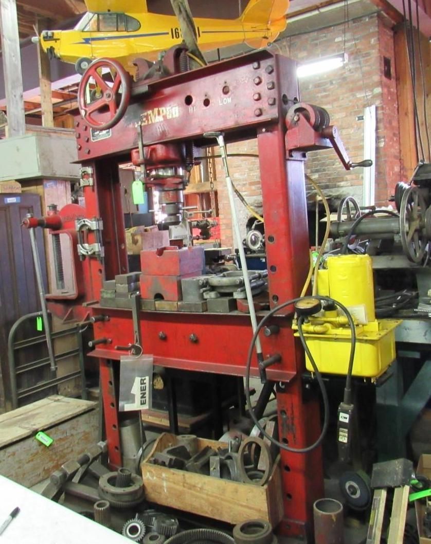 Red industrial press machine in a workshop.