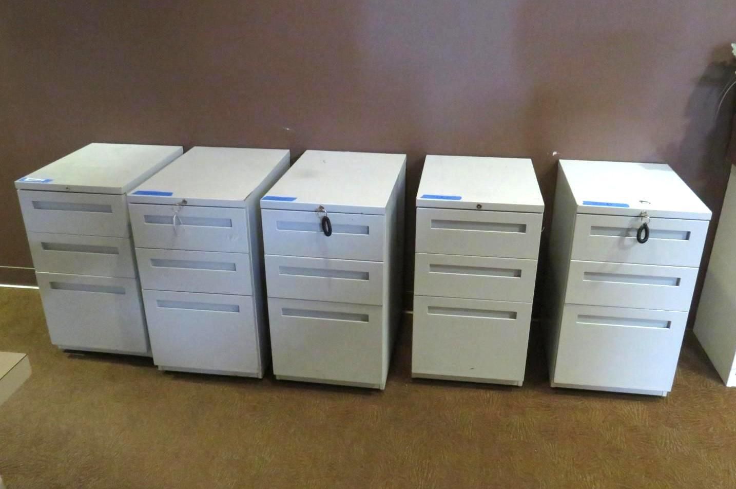 Five gray metal filing cabinets lined up against a brown wall and on a brown floor.